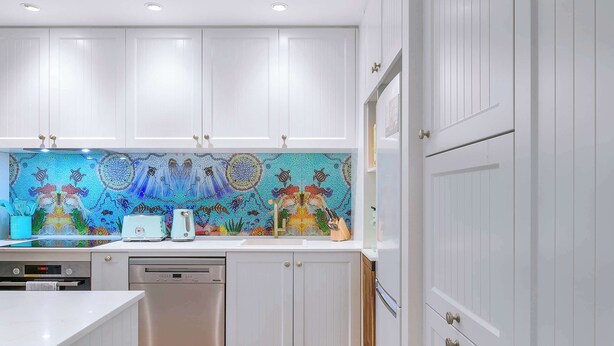 A kitchen with white cabinetry, a colorful backsplash, and modern appliances. - The Fishbowl! 1bed/1bath/1car/pool (Brisbane)