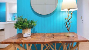 A wooden table with a round mirror and a lamp, a potted plant, and a white device on the table. - The Fishbowl! 1bed/1bath/1car/pool (Brisbane)