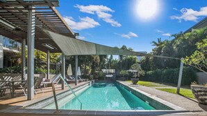 A swimming pool with a wooden deck, lounge chairs, and a shaded area. - The Fishbowl! 1bed/1bath/1car/pool (Brisbane)