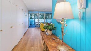 A hallway with a wooden floor, a blue wall, a white lamp, and a telephone. - The Fishbowl! 1bed/1bath/1car/pool (Brisbane)
