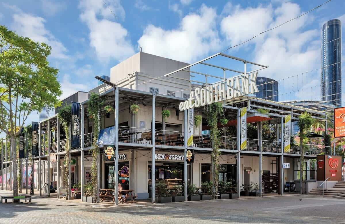 A modern building with multiple levels, featuring restaurants and a visible sign for 'South Bank.'