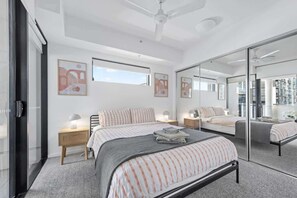 A modern bedroom with a large bed, bedside tables, a ceiling fan, and a large mirror. - South Bank Sensational! ~ 2bed/2bath/1car/pool! (Brisbane)