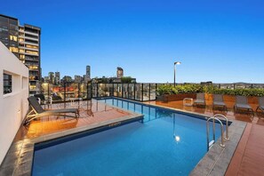 A rooftop pool with lounge chairs, a city skyline in the background, and a clear sky. - South Bank Stunner! ~ 3 Bed/2 Bath/1car/views (Brisbane)