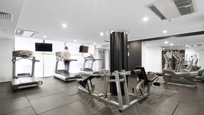 A gym with treadmills, a weight machine, and a TV screen. - Urban Retreat 1bed-1bath-study-balcony-1car (Brisbane)
