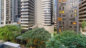 A high-rise building with multiple floors, balconies, and a logo on the side. - Urban Retreat 1bed-1bath-study-balcony-1car (Brisbane)