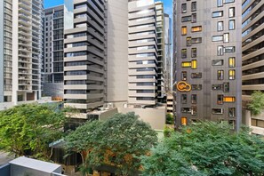 A high-rise building with multiple floors, balconies, and a logo on the side. - Urban Retreat 1bed-1bath-study-balcony-1car (Brisbane)