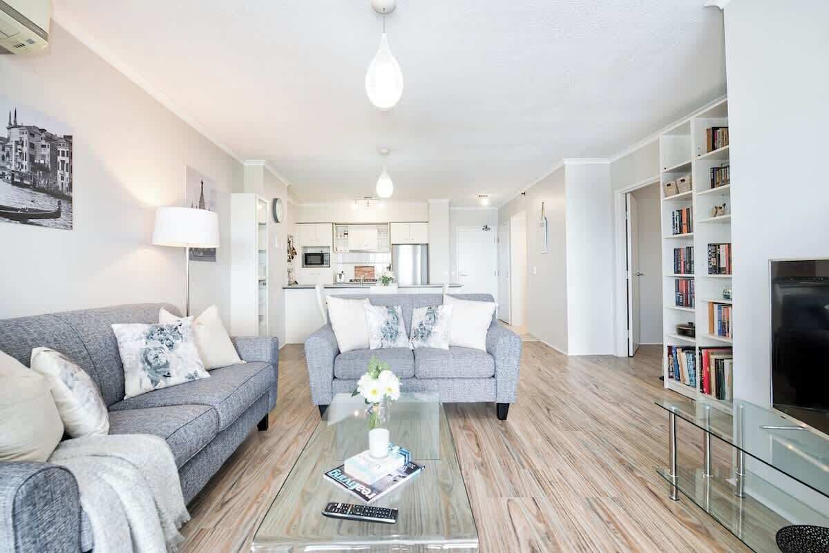 A modern living room with a sofa, coffee table, and bookshelf.