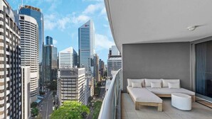 A balcony with a sofa and ottoman, overlooking a cityscape with modern buildings. - Top of the Town! 2bed/2bath/1car/balcony/views~cbd (Brisbane)