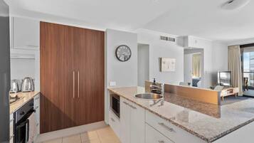 A modern kitchen with a built-in oven, microwave, and sink.