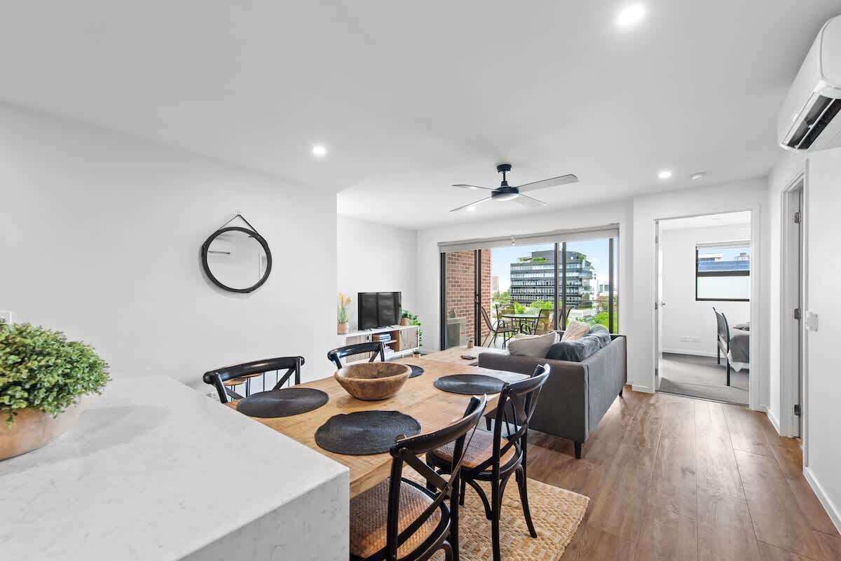A modern interior with a dining area, a sofa, and a TV.