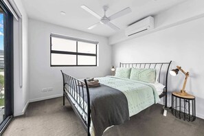 A bedroom with a bed, a window, a ceiling fan, and an air conditioning unit. - Stylish & Slick! 1bed/1bath/1car ~ Walk to CBD (Brisbane)