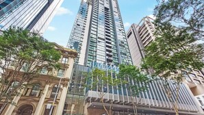 A high-rise building with a modern glass facade, a classical building with arched windows, and a tree-lined street. - City Centre! 1bed/1bath/study/1car/balcony ~ CBD (Brisbane)