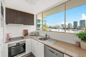 Eine moderne Küche mit Blick auf eine Stadtlandschaft und einen Yachthafen.