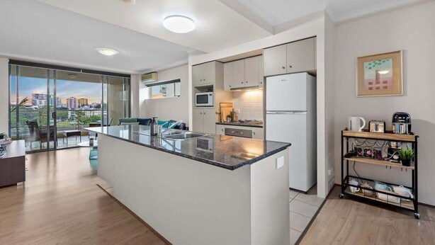 A modern kitchen with a central island, built-in appliances, and a city view. - Superb! 2bed, 2bath, 1car, Views ~ CBD (Brisbane)