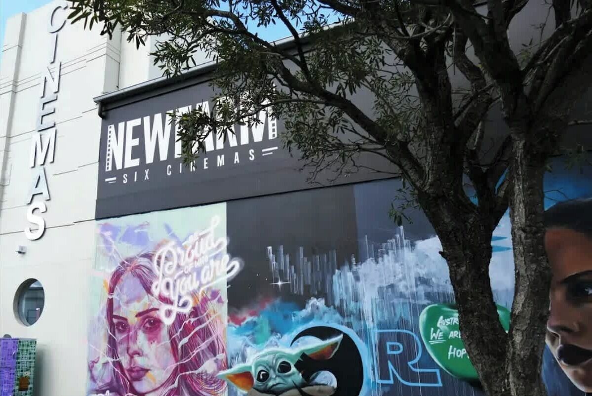 A cinema with a large mural featuring a character and text.