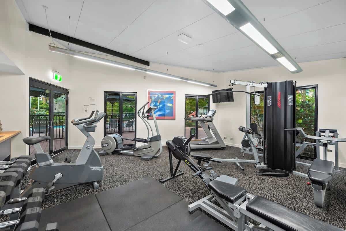 Een fitnessruimte met loopbanden, elliptische trainers en gewicht apparatuur.