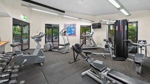 Ein Fitnessstudio mit Laufbändern, Crosstrainern und Krafttrainingsgeräten.