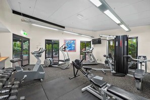 Ein Fitnessstudio mit Laufbändern, Crosstrainern und Krafttrainingsgeräten.