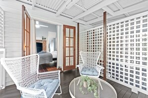 A room with white wicker chairs, a round table with a plant, and a white lattice partition. - The Fireplace! 1 Bed/1 Bath/1 Car ~ New Farm (Brisbane)