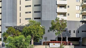 Ein mehrstöckiges Gebäude mit moderner Architektur, mit Balkonen und einem Schild, das die Adresse angibt.