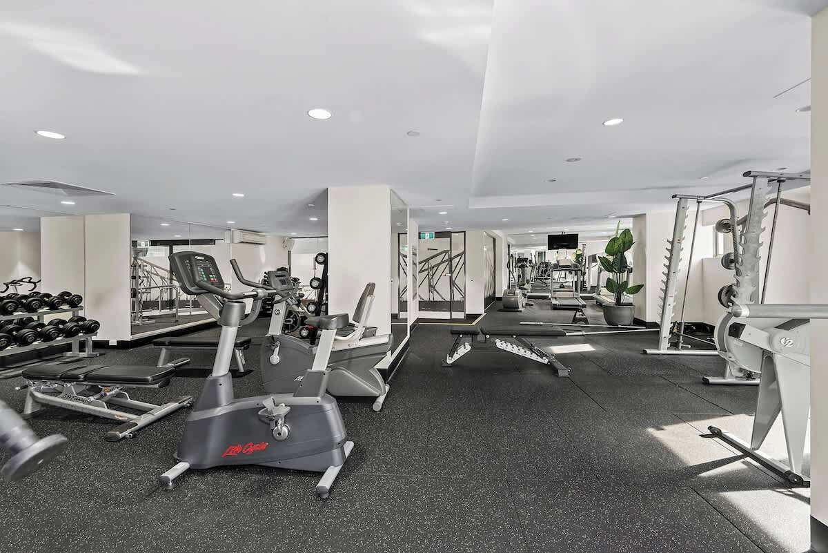 Ein Fitnessstudio mit Cardiogeräten, Krafttrainingsgeräten und Kurzhanteln.