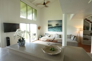 Ein modernes Wohnzimmer mit Flachbildfernseher, Couchtisch und Sofa.