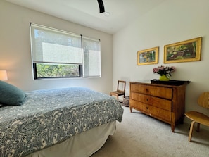 A bedroom with a bed, a dresser, a chair, and two framed pictures on the wall. - Stylish, modern living on 2.5 acres near Denver. (Morrison)
