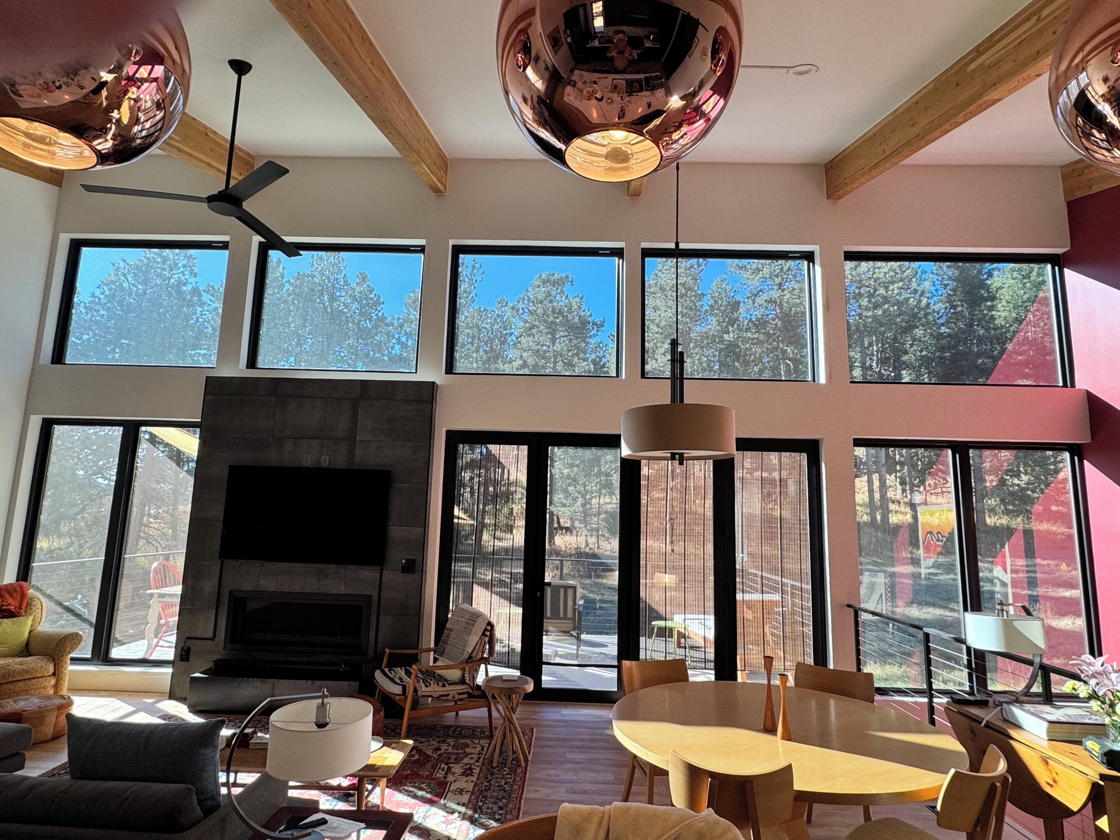 A spacious living room with a fireplace, large windows, and a dining area.