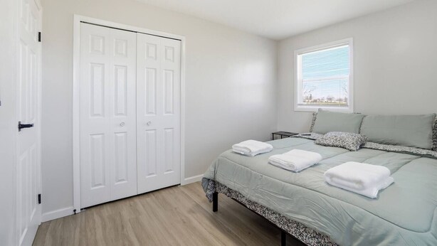 A bedroom with a bed, two pillows, a window with blinds, and a white wardrobe. - Cozy 3BR Home Close to WSU, UD & Wright-Patt AFB (Dayton)