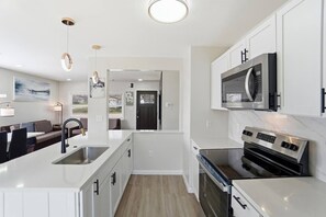 Een moderne keuken met witte kastjes, roestvrijstalen apparatuur en een centraal eiland.