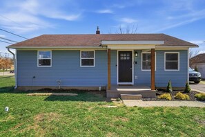 A single-story house with a front porch, a garage, and a small front yard. - Cozy 3BR Home Close to WSU, UD & Wright-Patt AFB (Dayton)