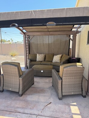 An outdoor seating area with a covered patio, a sofa, and two armchairs. - Lake Havasu Getaway- Private Pool-4BR -Sleeps 10- Family Fun (Lake Havasu City)