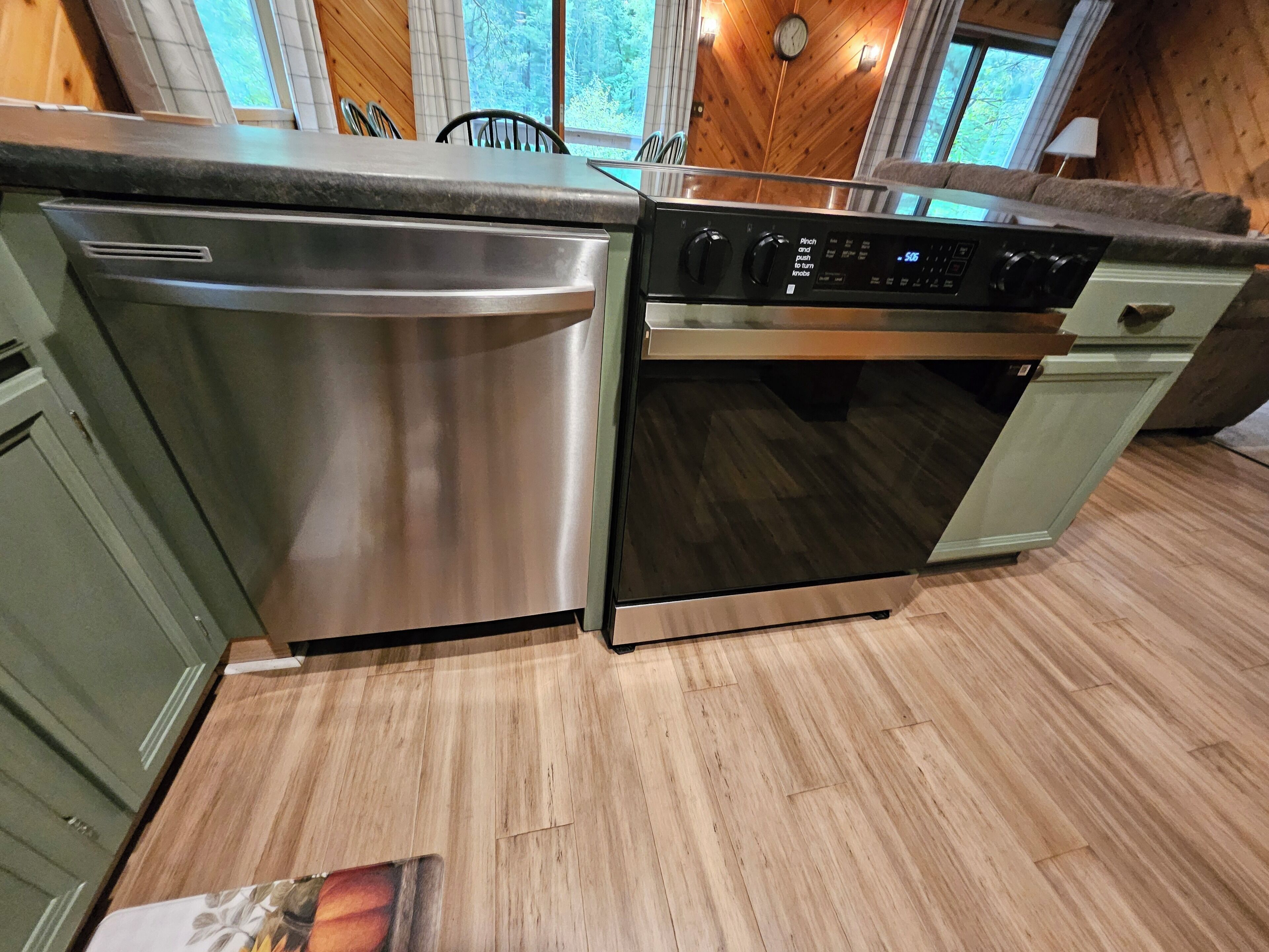 Une cuisine équipée d’appareils électroménagers en acier inoxydable, de meubles en bois et offrant une vue sur l’extérieur.
