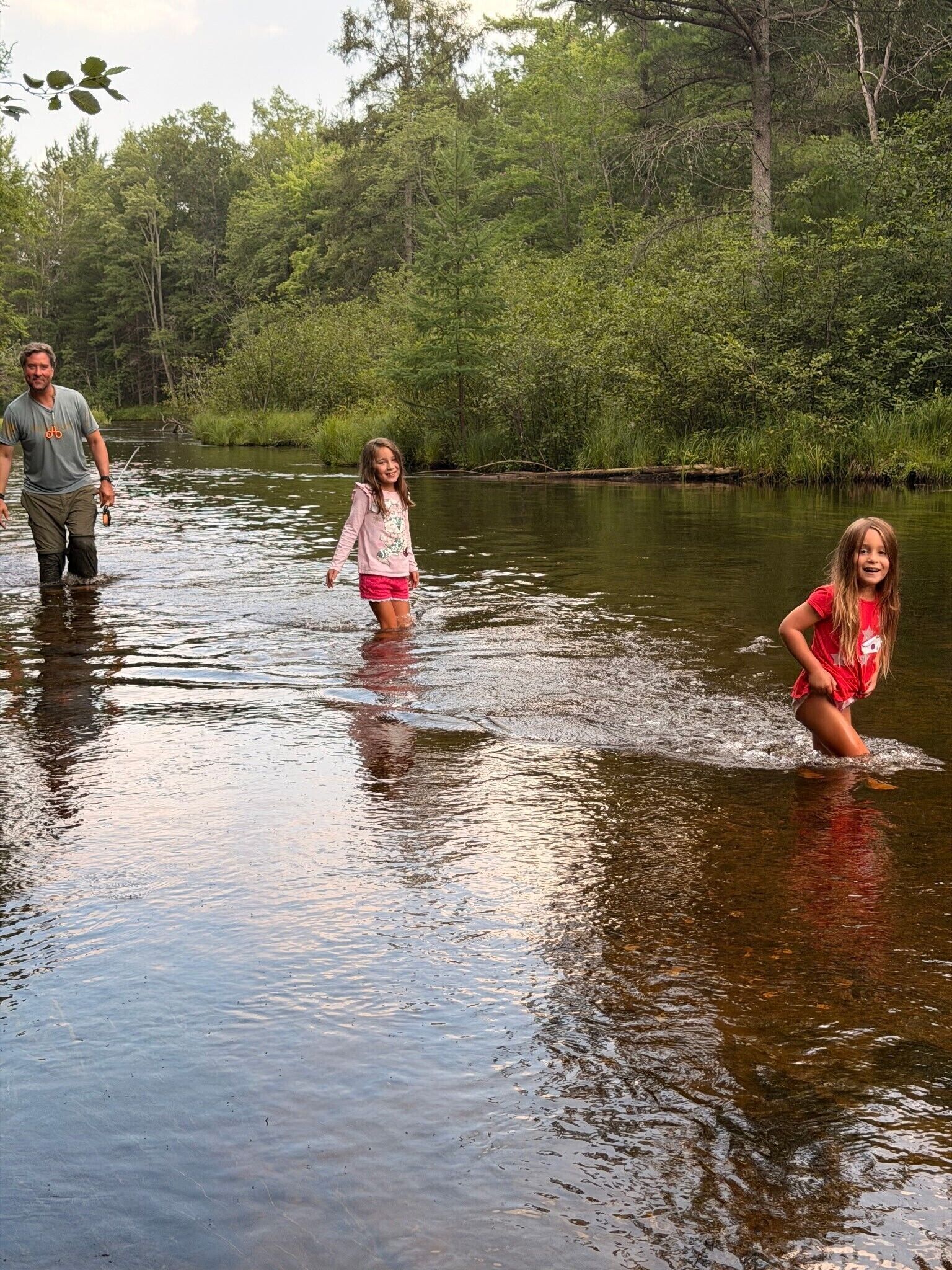 A river with people wading through it.