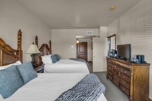 A hotel room with two beds, a dresser, a television, and a door leading to another room. - Zermatt Mountain Retreat (Midway)