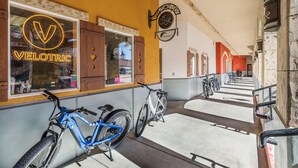 Una bicicleta estacionada frente a un edificio con un letrero de neón que dice 'VELOTRIC'.