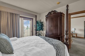 A bedroom with a large bed, a wooden wardrobe, and a window with blinds. - Zermatt Resort | Close to Deer Valley East Village (Midway)