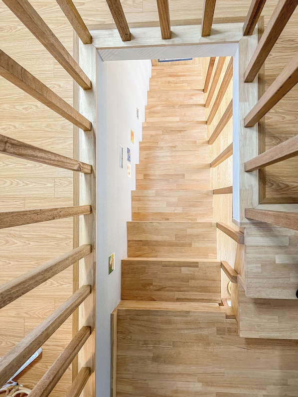 A wooden staircase with a modern design, leading to a higher floor.