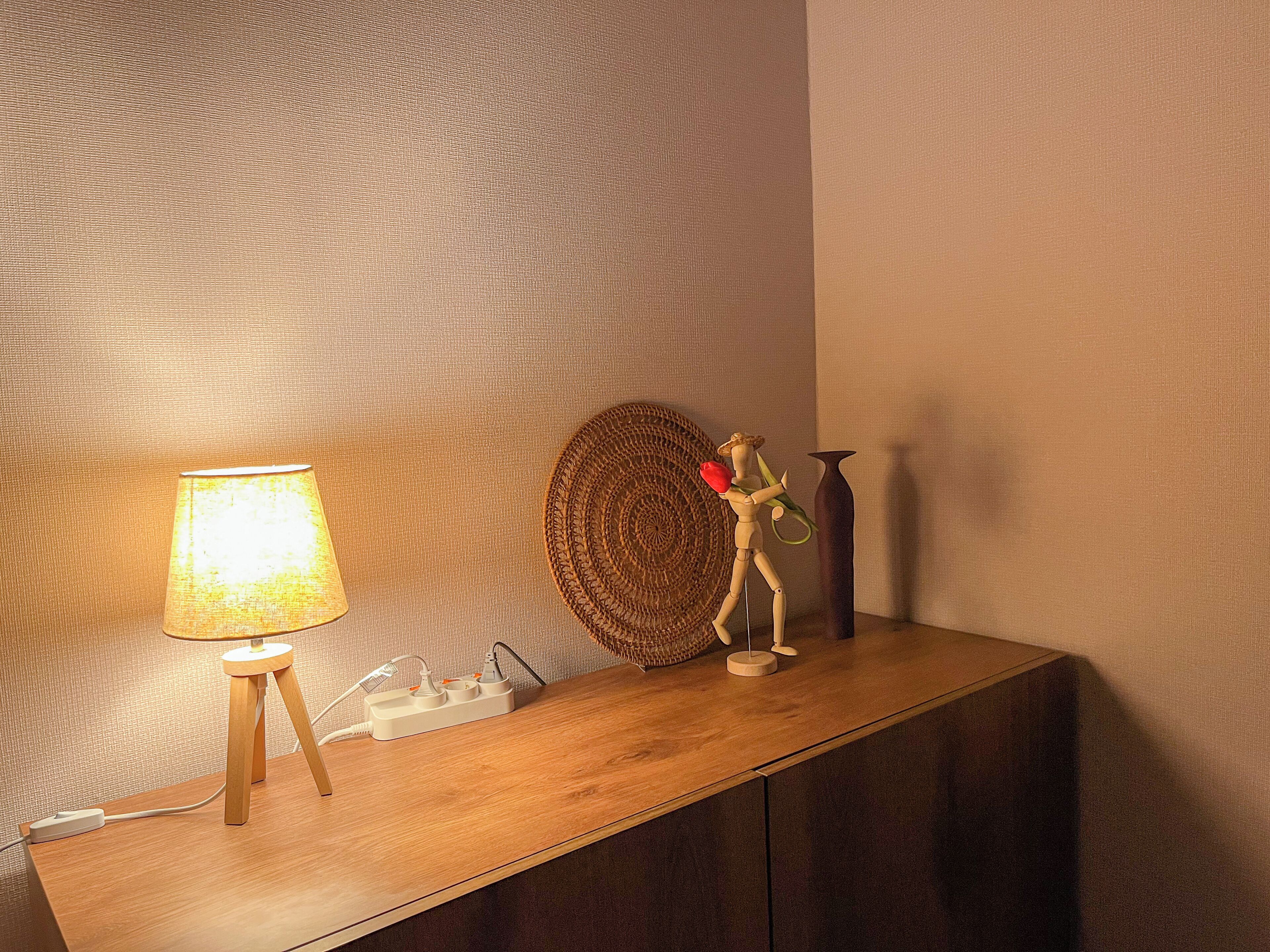 A wooden console table with a lamp, a decorative item, and a vase.