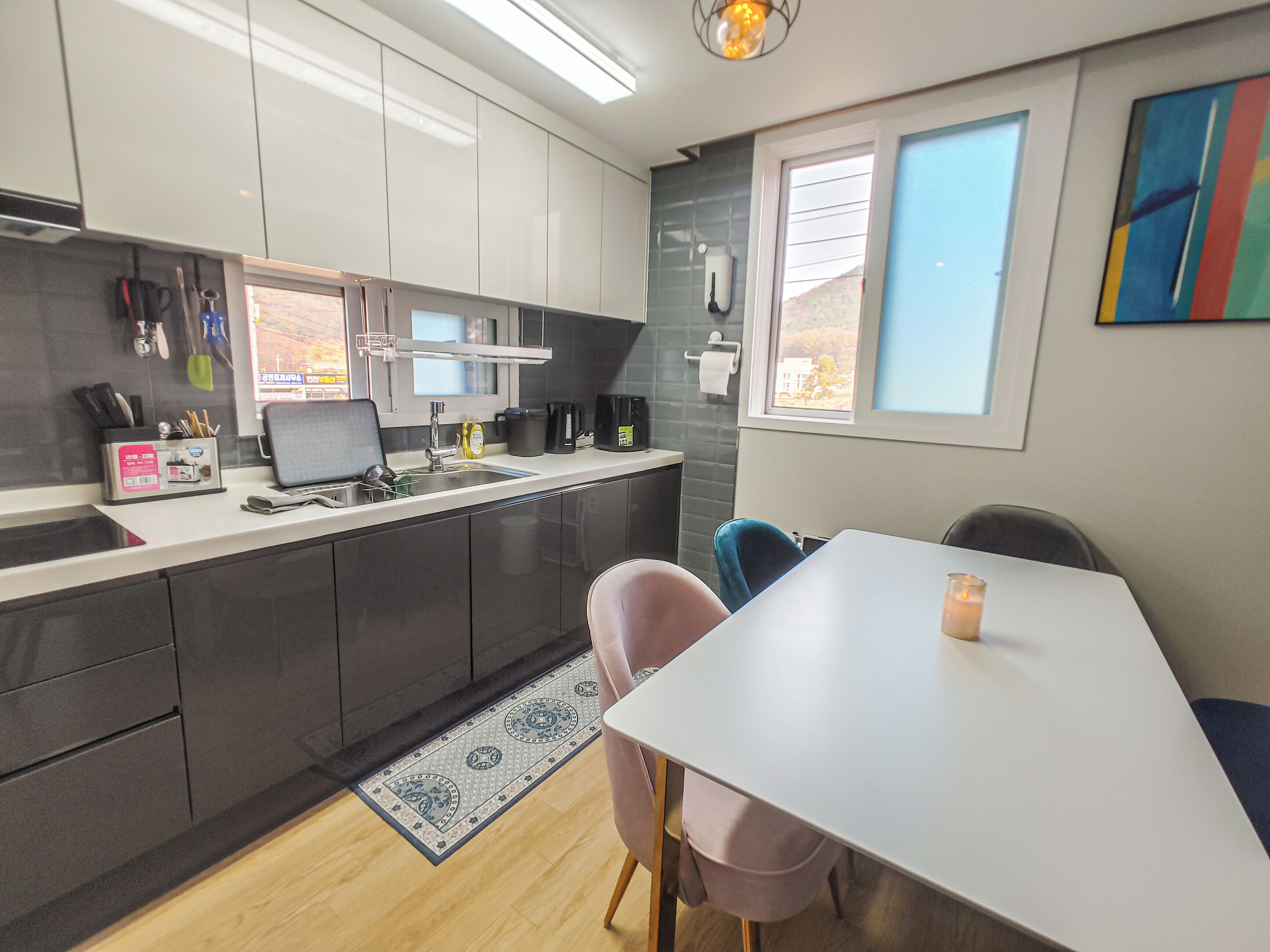 A modern kitchen with a dining area, equipped with a sink, stove, and a dining table with chairs.