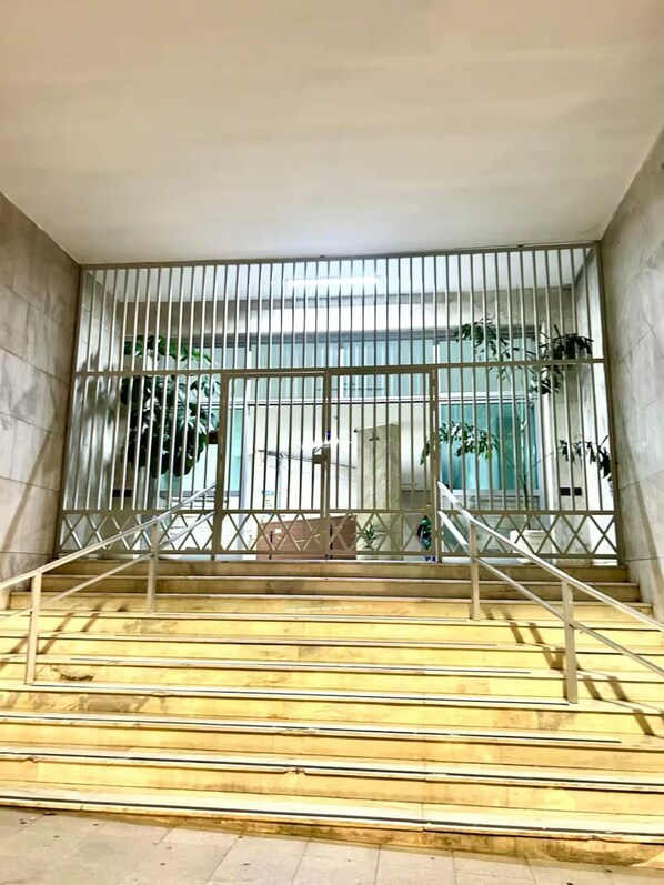 A staircase with metal railings leading to a glass door.