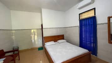 Un dormitorio con cama, escritorio y silla.