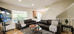 A living room with a sofa set, a coffee table, and a chessboard. - Cozy 4BR Retreat | Entire House | King Bed | Airport | Ring Road | Games | Banff (Calgary)