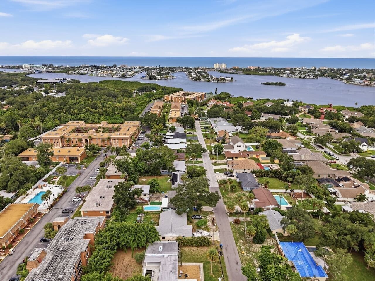 Vista aérea de uma área residencial com casas, ruas e um corpo d'água.