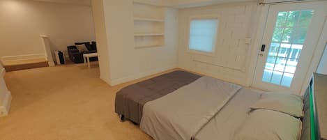Ein Schlafzimmer mit Bett, Fenster und Tür.