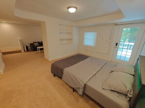 Ein Schlafzimmer mit Bett, Fenster und Tür.