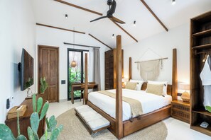 A bedroom with a four-poster bed, wooden beams, a ceiling fan, a TV, and a wardrobe. - Capri Villa by DH (Gianyar)