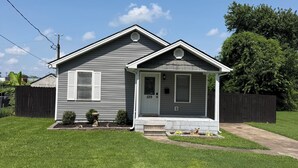 A single-story house with a front porch, a small front yard, and a mailbox.