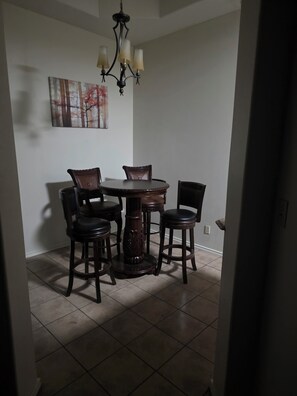 A dining area with a round table and four chairs, a chandelier, and a painting on the wall. - Spacious 5-bedroom house in marvelous San Juan Texas . Pet friendly home. 
. (San Juan)