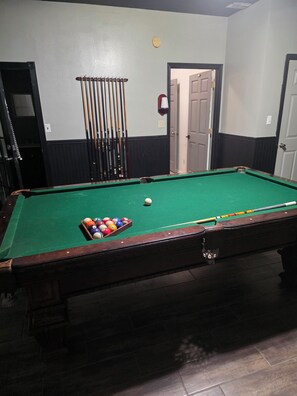 A pool table with balls and cues, a door, and a wall clock. - Spacious 5-bedroom house in marvelous San Juan Texas . Pet friendly home. 
. (San Juan)